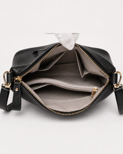 Open black PORT&LOTUS crossbody bag showing organized interior compartments with divider pockets and zip section