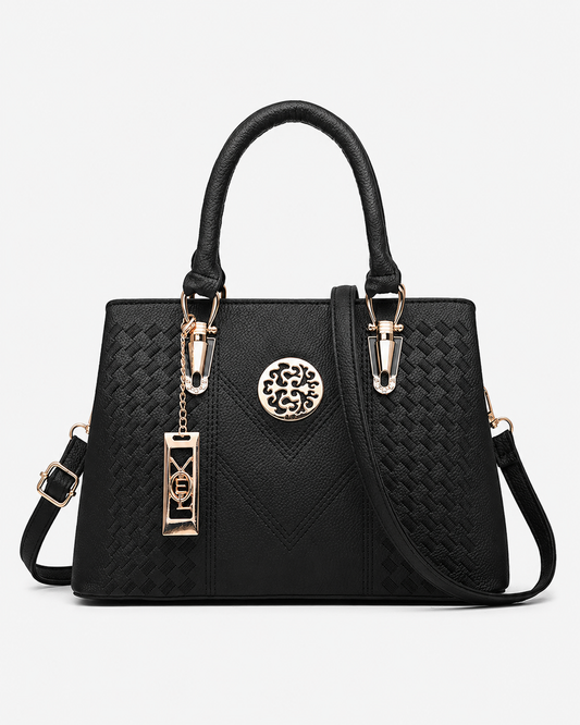 front view of black PORT&LOTUS woven embossed top handle satchel bag detachable crossbody strap vintage gold metal pendant plain white background