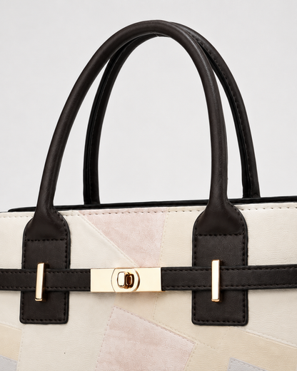 Close-up of ivory patchwork tote bag with dark brown top handles and polished gold-tone front turn-lock hardware