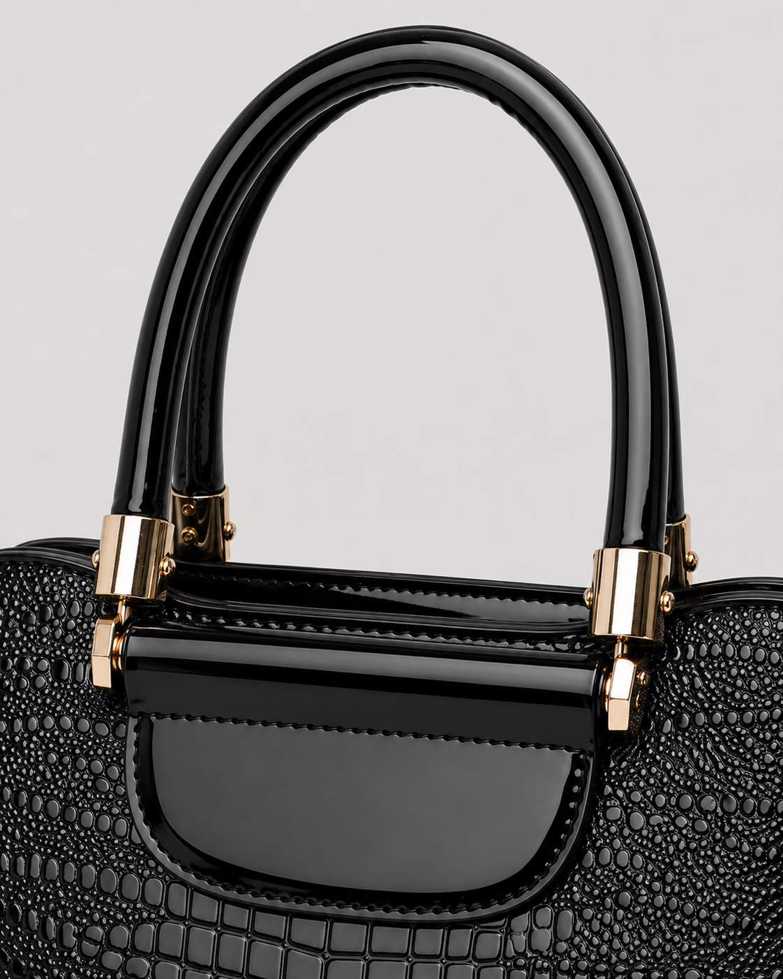 Close-up of black PORT&LOTUS handbag with glossy top handles crocodile texture and polished gold-tone fittings