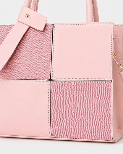 Close-up of pink structured tote bag showing smooth and textured square panels with detachable shoulder strap hardware