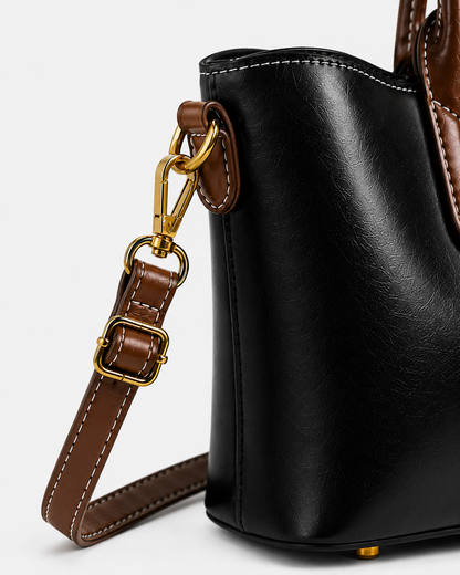 Close-up of PORT&LOTUS black tote bag with detachable brown shoulder strap adjustable buckle swivel clasp and gold-tone hardware